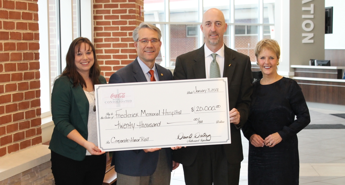 Group of people holding a large check